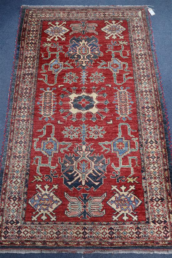 A Caucasian design brick red ground rug 180 x 110cm